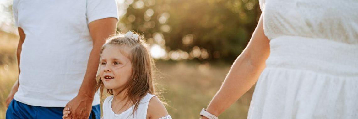 A man and a woman holding hands with a little girl